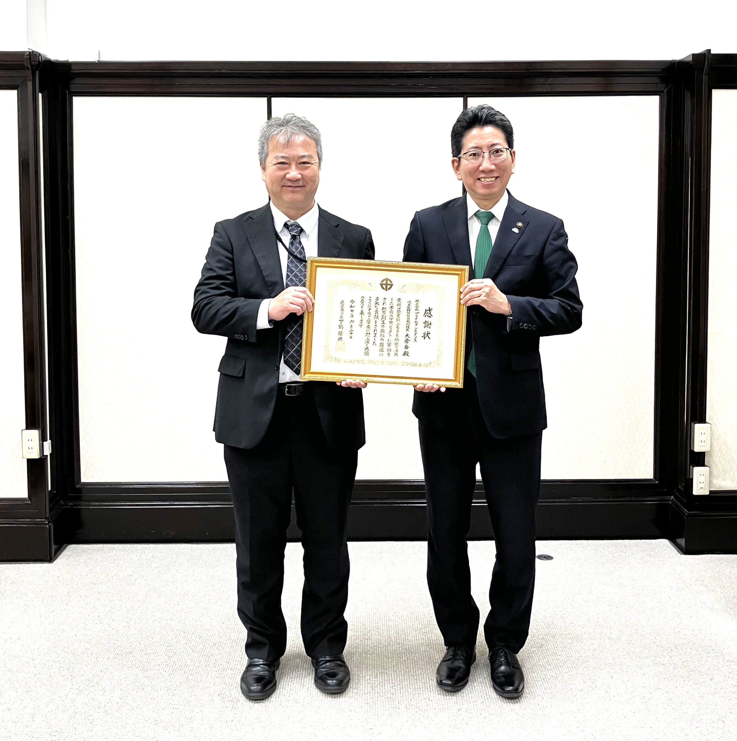 大倉社長、下鶴鹿児島市長が笑顔で感謝状を持っている様子